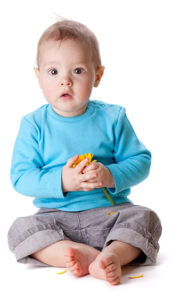 Liten baby innehav gul blomma — Stockfoto