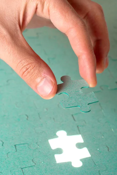 手、hol に緑色のジグソー パズルの行方不明の部分を挿入します。 — ストック写真