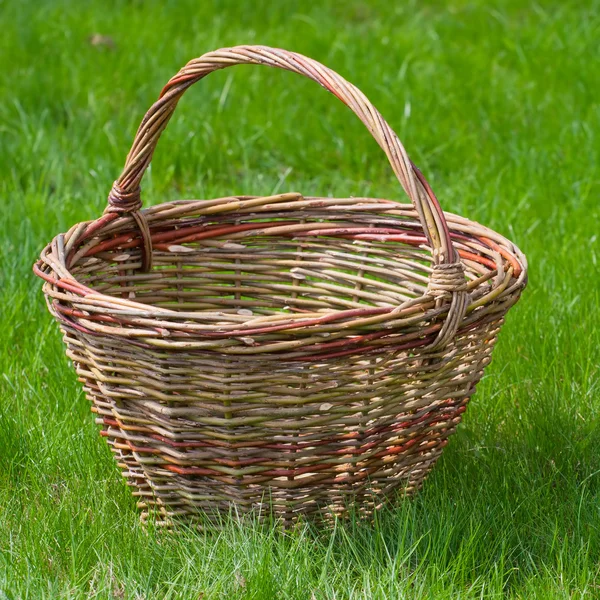 Старий плетений кошик на зеленій садовій траві — стокове фото