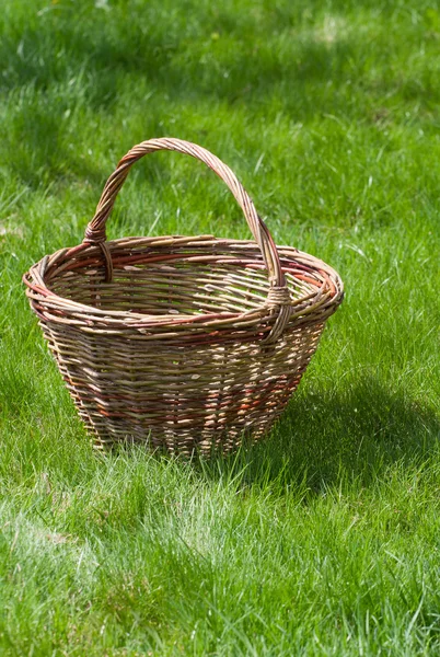 Oude rieten mand op een groene tuin gras — Stockfoto