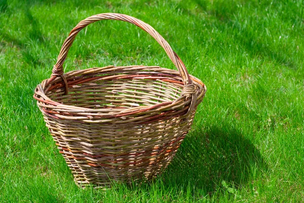 Vecchio cestino di vimini su un'erba verde giardino — Foto Stock