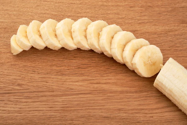 Sliced bananas on a wooden background — Stock Photo, Image