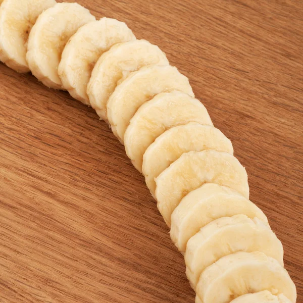 Plasterki banany na tle drewniane — Zdjęcie stockowe