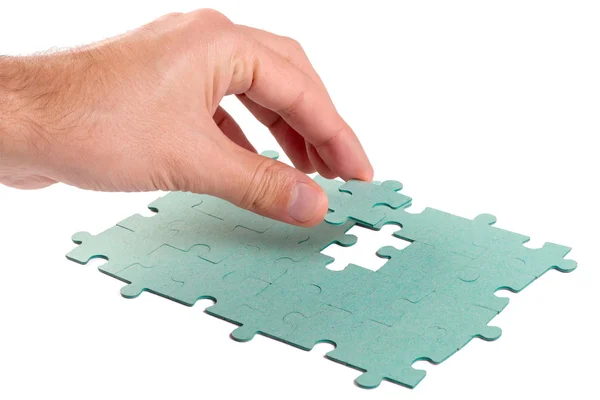 Hand ontbrekende stuk van groene puzzel invoegen in het hol — Stockfoto