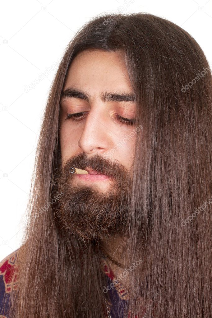 Long-haired hippie man smoking cigarette or marijuana joint