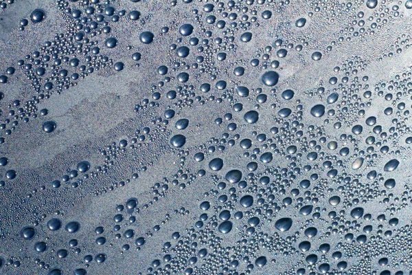 Gotas de água sobre um fundo cinza-azul — Fotografia de Stock