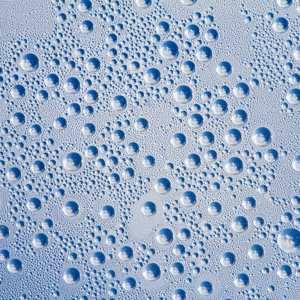 Gotas de água sobre um fundo cinza-azul — Fotografia de Stock