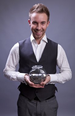 Young business man holding jar with coins clipart