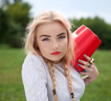 bir kırmızı bir yeşil çayır kova ile şık sarışın.