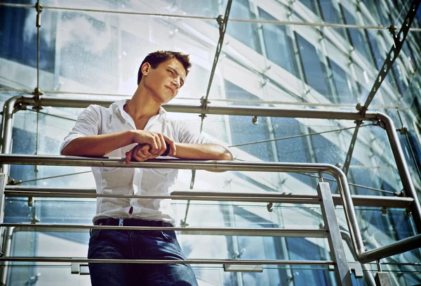 Stilvoller junger Mann im weißen Hemd an einer weißen Pausenwand — Stockfoto