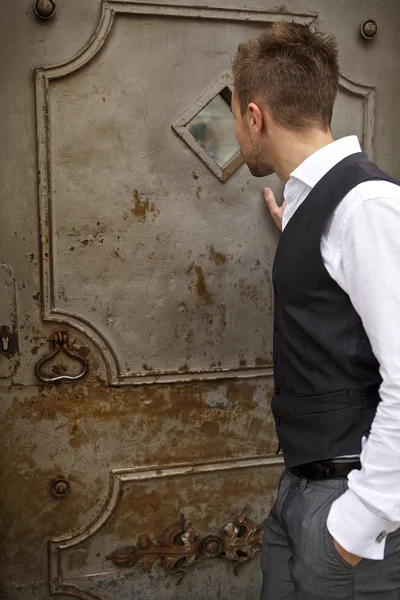 Красивый молодой человек возле старой металлической двери — стоковое фото