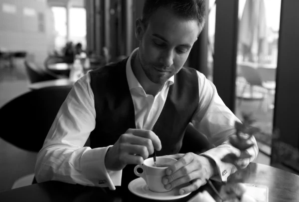 Jonge aantrekkelijke zakenman heeft koffie een pauze. zwart-wit foto. — Stockfoto