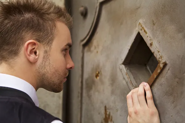 Красивый молодой человек возле старой металлической двери — стоковое фото
