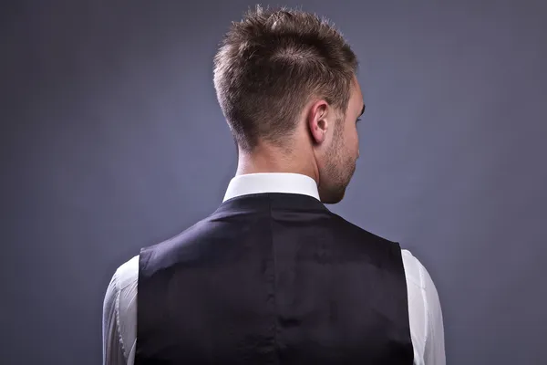 Young business man from back, isolated on gray. — Stock Photo, Image