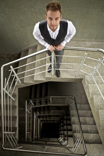 Aantrekkelijke jongeman vormen op ladder. — Stockfoto