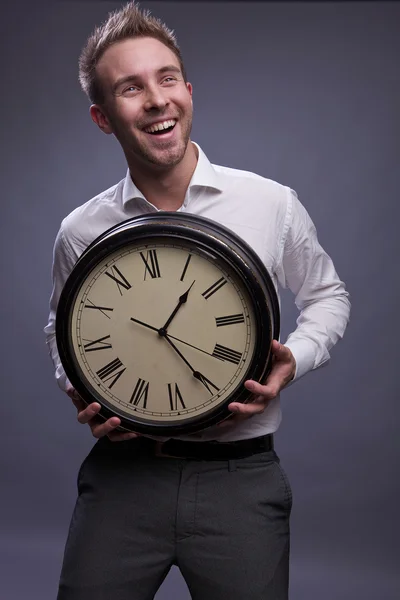 Przystojny biznesmen posiadania zegar. — Zdjęcie stockowe