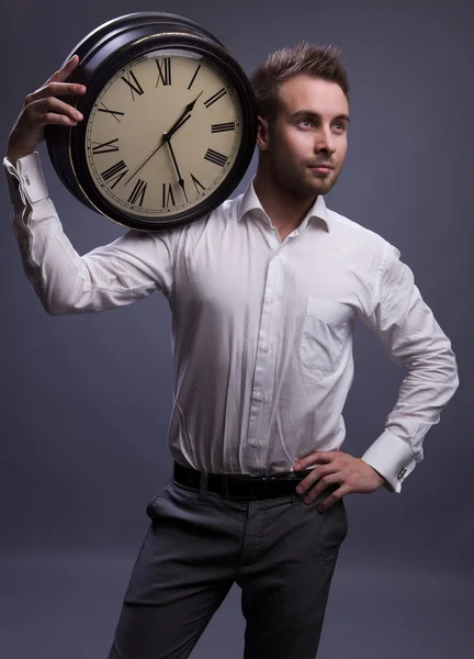 Przystojny biznesmen posiadania zegar. — Zdjęcie stockowe