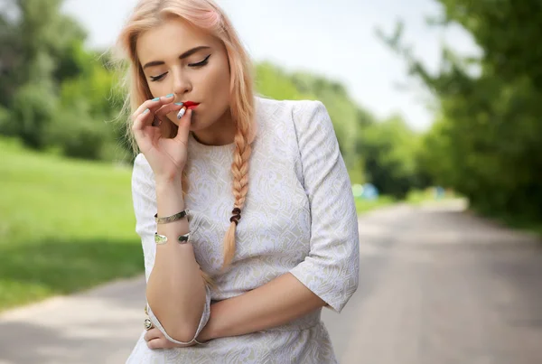 Женщина с сигаретой в летних пейзажах — стоковое фото