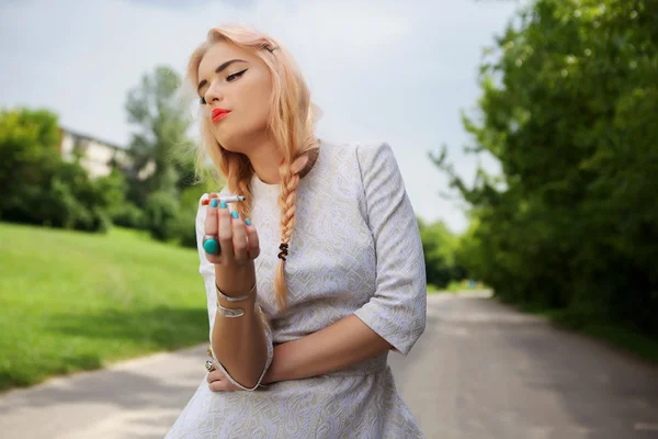 Woman with cigarette in summer scenery — Stock Photo, Image
