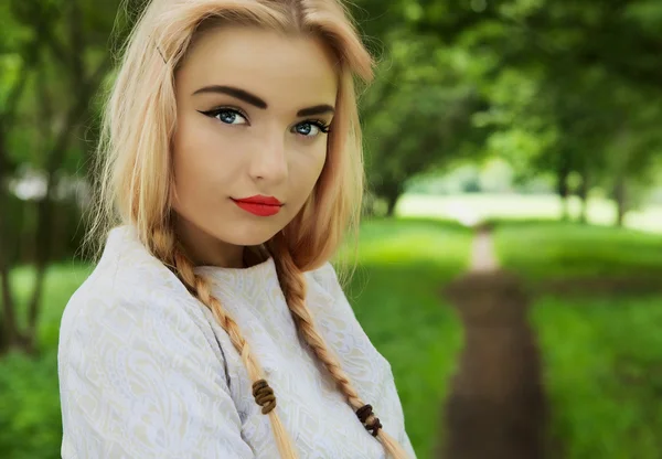 Modische junge Blondine posiert in Parkallee — Stockfoto