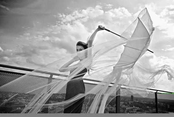 Romantic beauty with umbrella on a skyscraper roof. — Stock Photo, Image