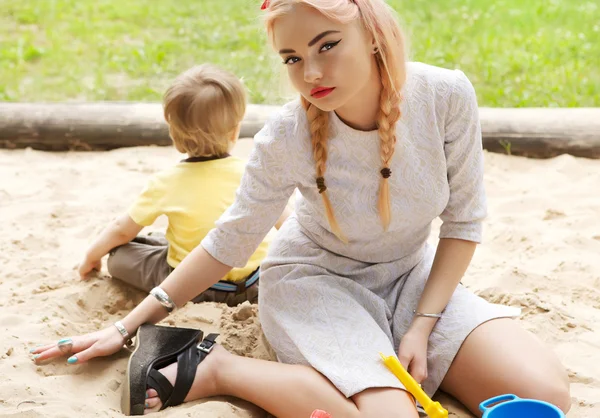 Μόδα ξανθό κορίτσι σε ένα sandbox. — Φωτογραφία Αρχείου