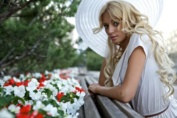 Portrait de belle femme blonde en chapeau rétro blanc près du parc — Photo