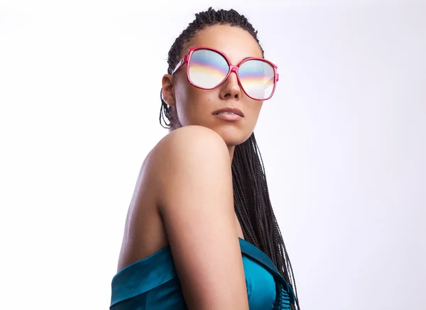 Beautiful fashion mulatto woman wearing sunglasses over a white background. — Stock Photo, Image