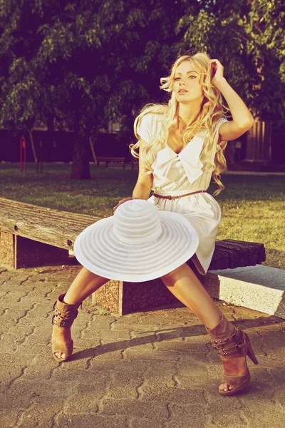 Porträtt av en vacker modell i vit retro hatt. Street mode foto. — Stockfoto
