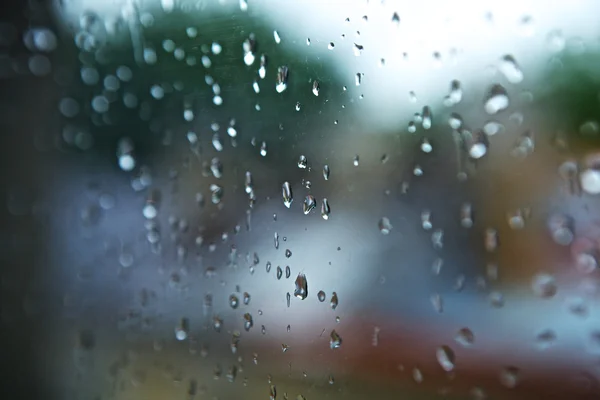 Nasse Fenster mit Regentropfen und wolkenverhangenem, stürmischem Himmel draußen — Stockfoto