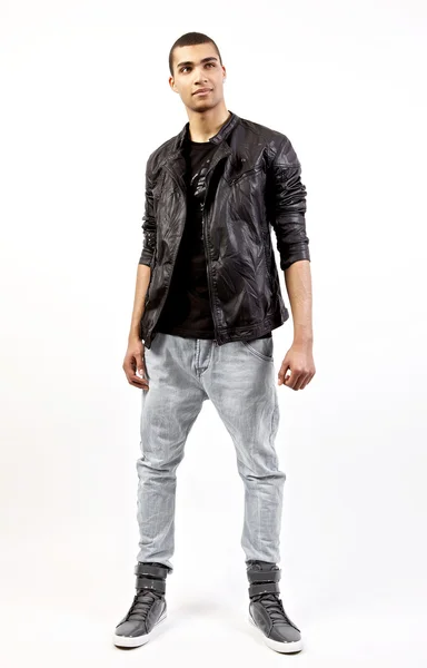 Attractive mulatto in a leather jacket on studio background. — Stock Photo, Image