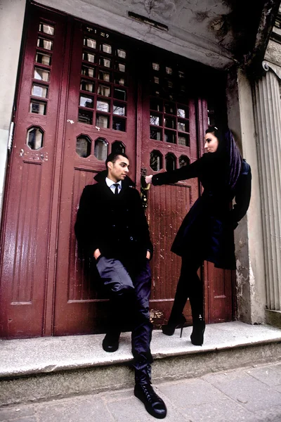 Coppia giovane vicino a un ingresso in un vecchio edificio. Sera riprese all'aperto . — Foto Stock