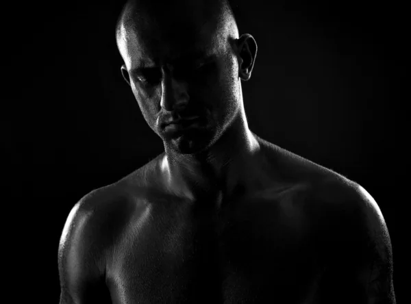 Hombre atlético fuerte sobre fondo negro Imagen de archivo