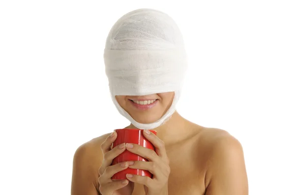 Mujer joven con la cabeza vendada con taza roja —  Fotos de Stock