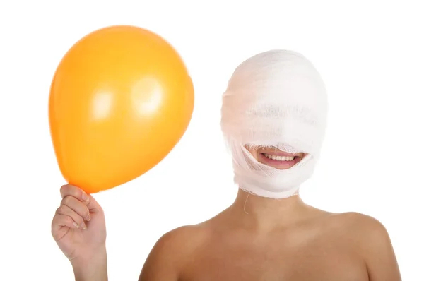 Kobieta z bandażowane w sposób głowy i balony — Zdjęcie stockowe