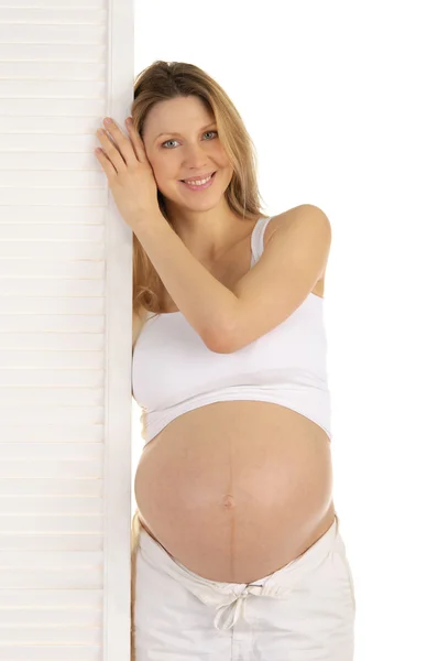 Mulher grávida feliz de pé perto da porta — Fotografia de Stock