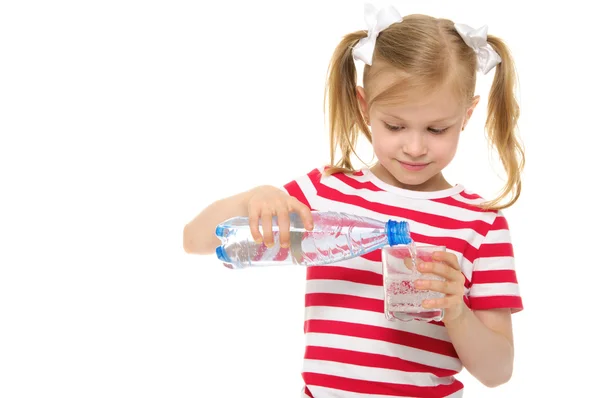 Girl pours water from bottle into glass — Stock Photo, Image
