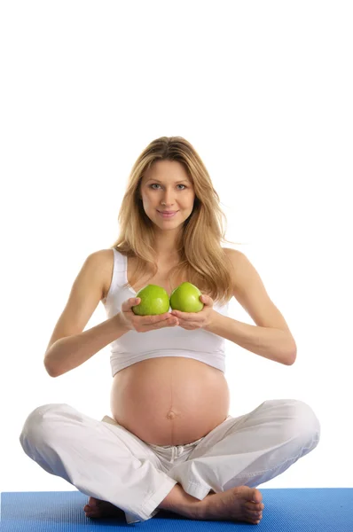 Hamile kadın pratik Yoga ve tutar elma — Stok fotoğraf