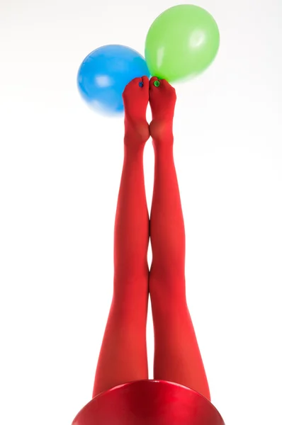 Pies femeninos en medias rojas con globos — Foto de Stock
