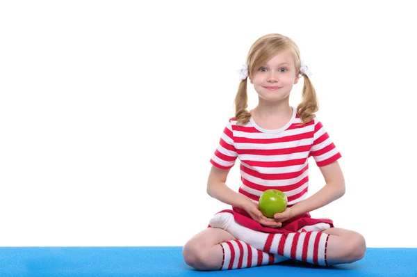 Girl with open eyes practice yoga and keep apple — Stock Photo, Image