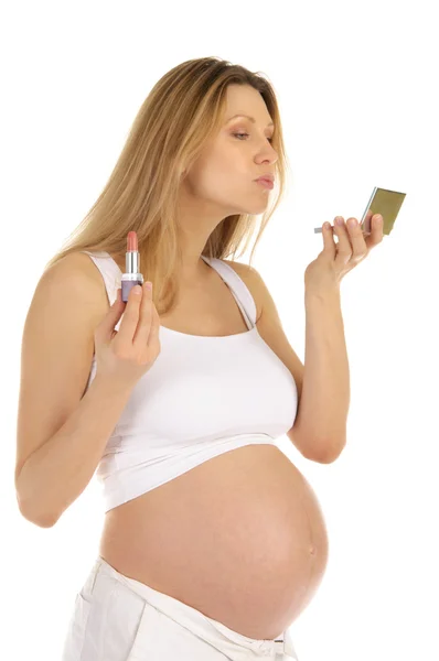 Беременная женщина и зеркало с помадой — стоковое фото
