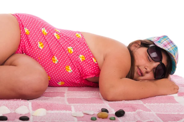 Meisje in zwembroek slapen op het strand — Stockfoto