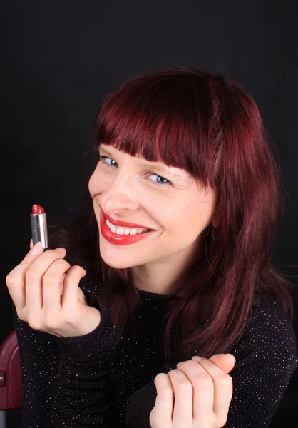 Redhead holding lipstick tube — Stock Photo, Image