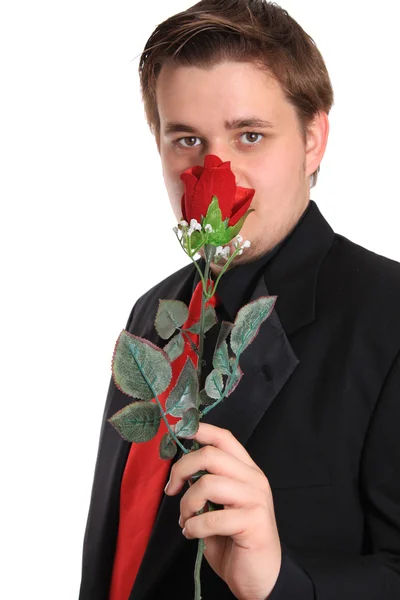 Молодой человек пахнет розой — стоковое фото