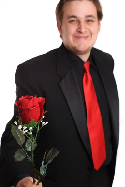 Νεαρός άνδρας, που σας προσφέρει ένα τριαντάφυλλο — Φωτογραφία Αρχείου