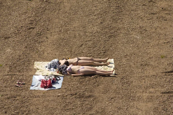 Stock image Women sunbathing beach stone