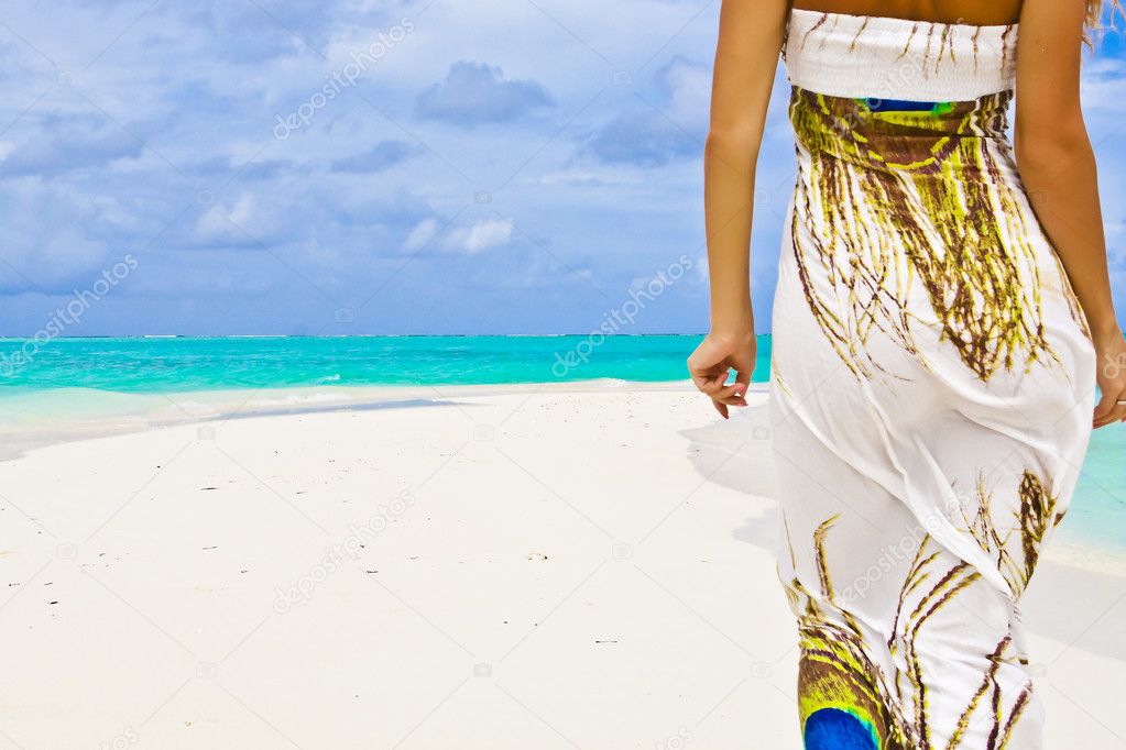 Banner of slender young woman walking alone on a beautiful beach