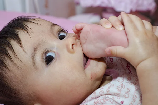 그녀의 발가락을 빠는 아기 소녀 — 스톡 사진