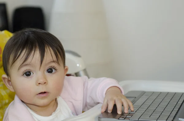 1 år baby flicka som försöker använda sin netbook — Stockfoto