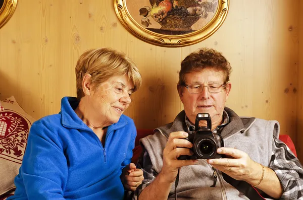 Seniorenpaar wedelt mit Bildern in die Kamera — Stockfoto